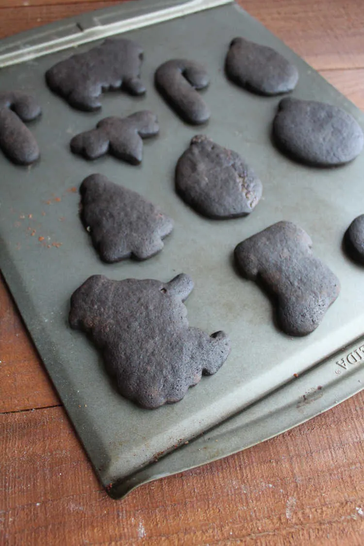 black cookies cut into fun shapes on sheet pan.