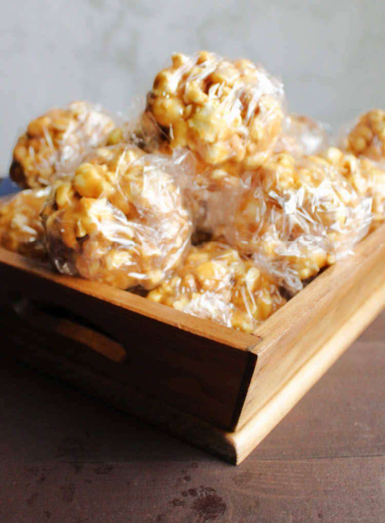wooden basket filled with peanut butter popcorn balls wrapped in plastic