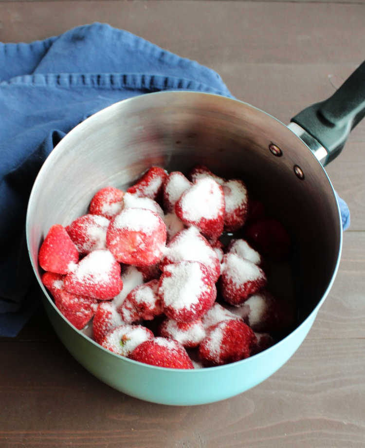 saucepan full of strawberries, sugar and lemon juice to make topping for cheesecakes