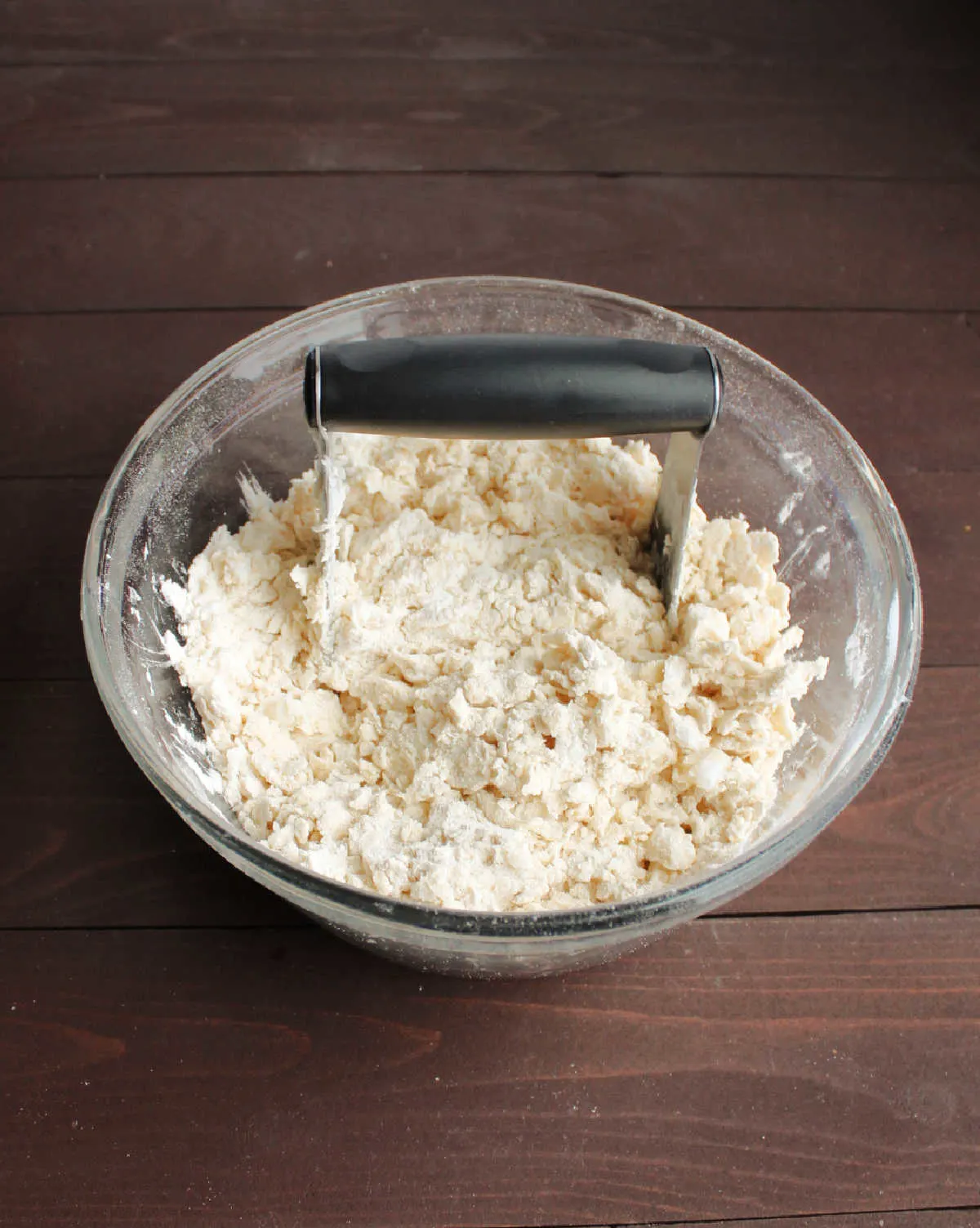 pastry cutter cutting lard into flour for pie crust. 