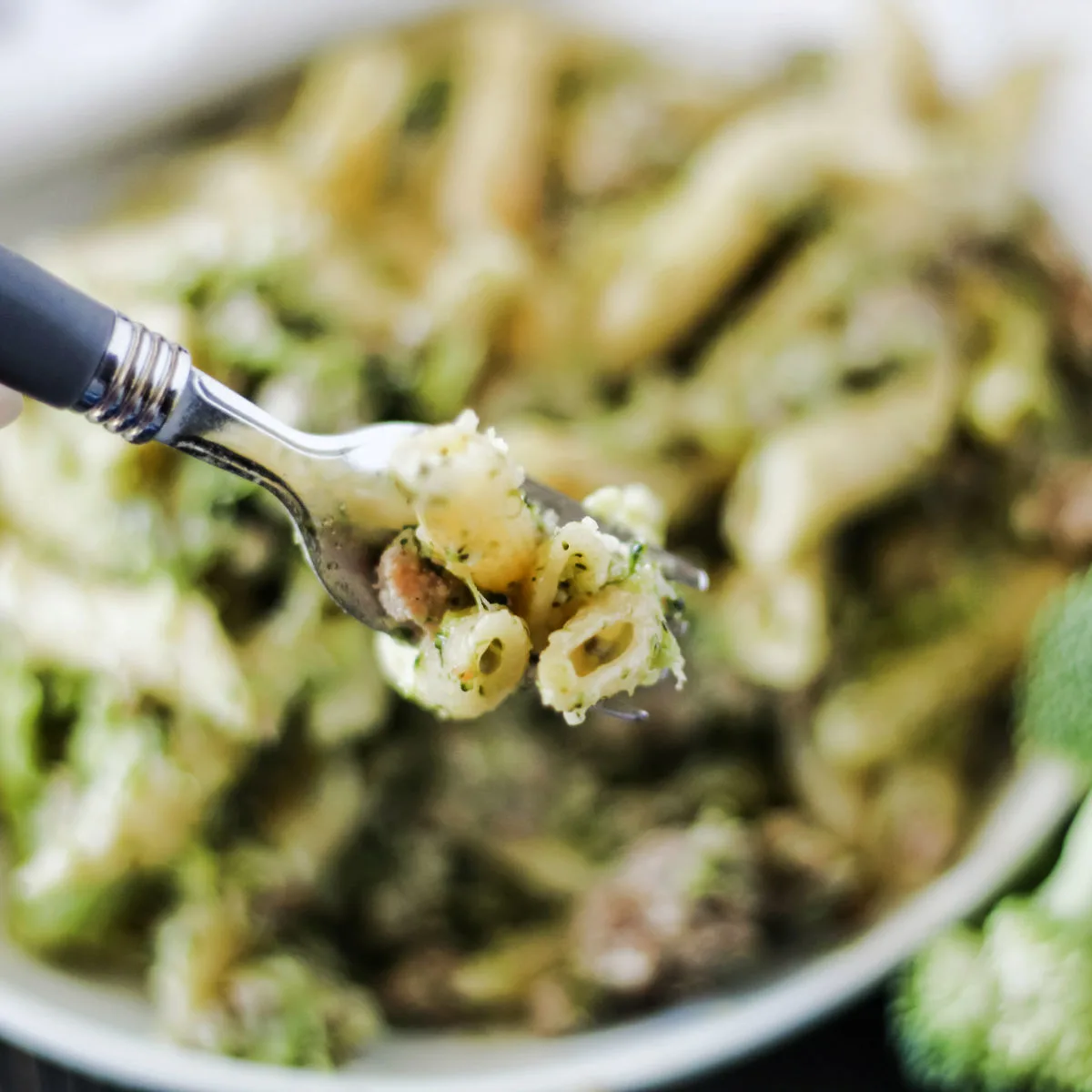 forkful of penne pasta with broccoli and Italian sausage