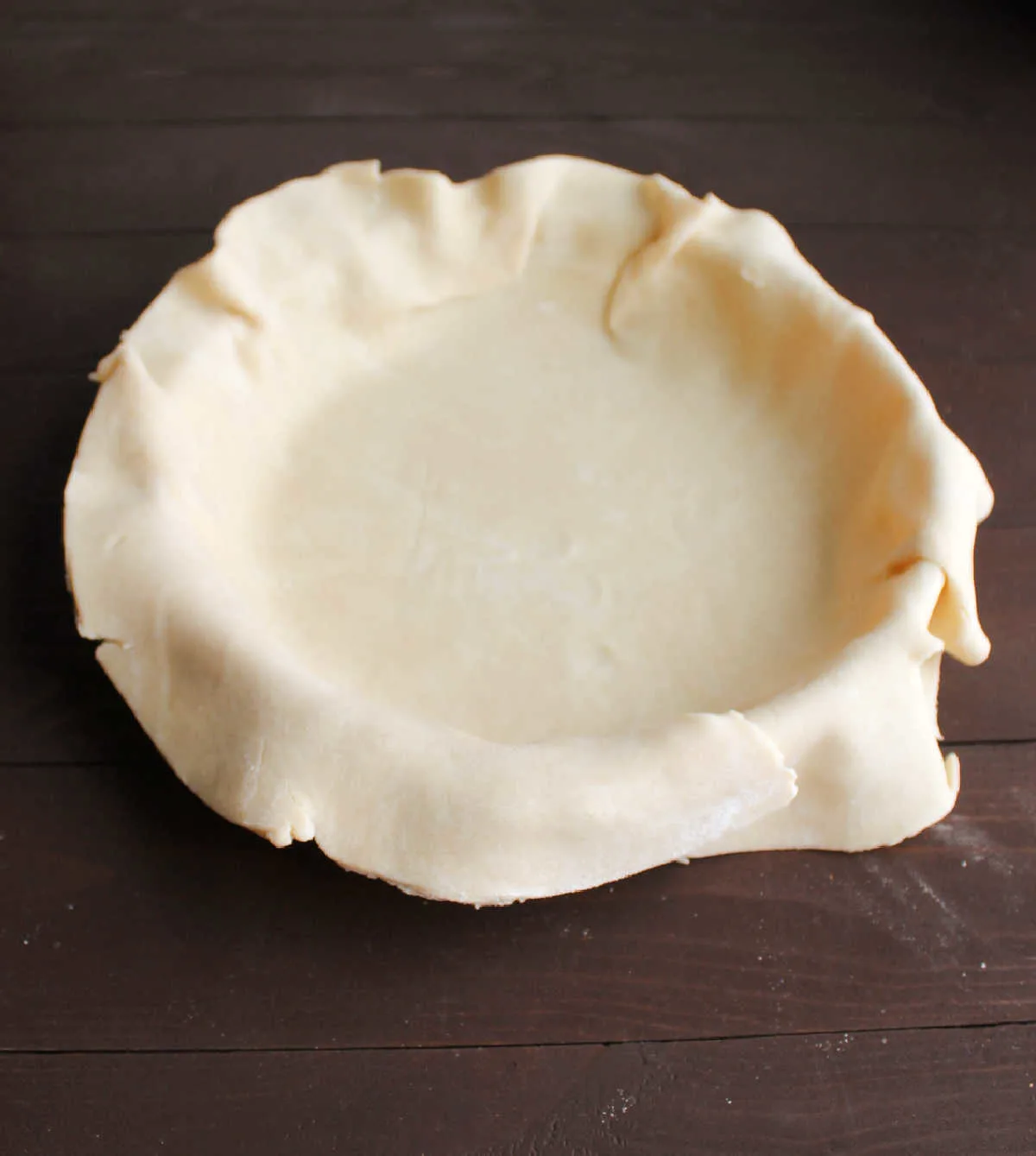 pie crust dough in pie pan, ready to be trimmed and filled.