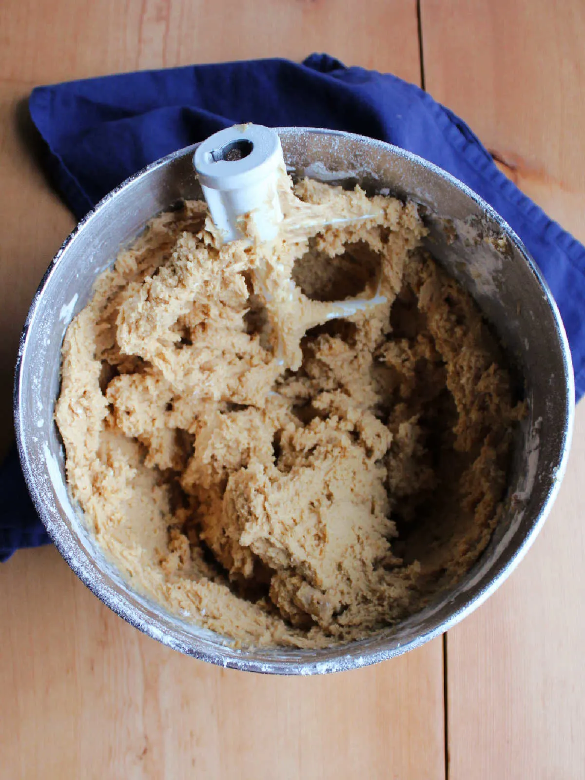 mixer bowl filled with peanut butter cookie dough and mixer paddle.