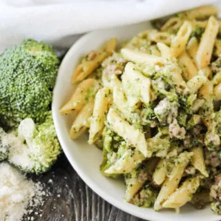 plate full of penne pasta with broccoli Italian sausage and Parmesan cheese ready to eat
