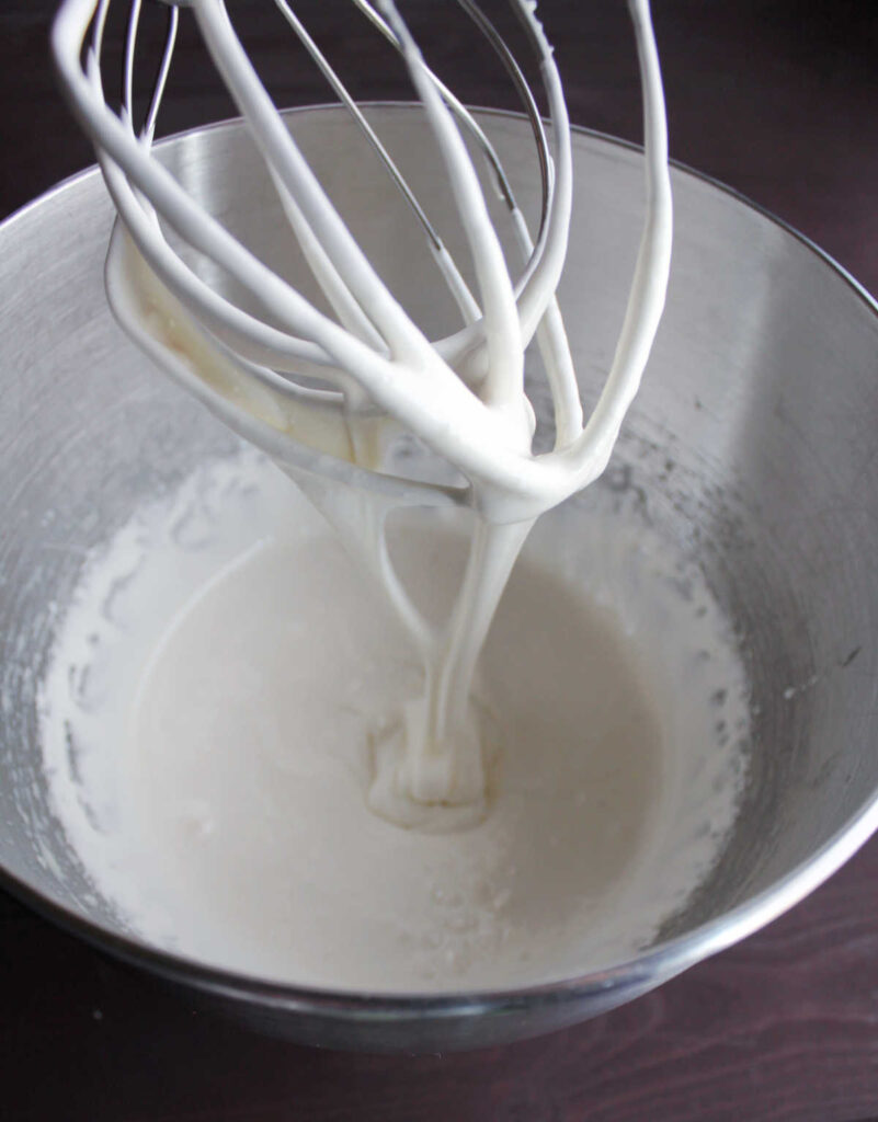 aerated white whipped sweetened condensed milk on beater.