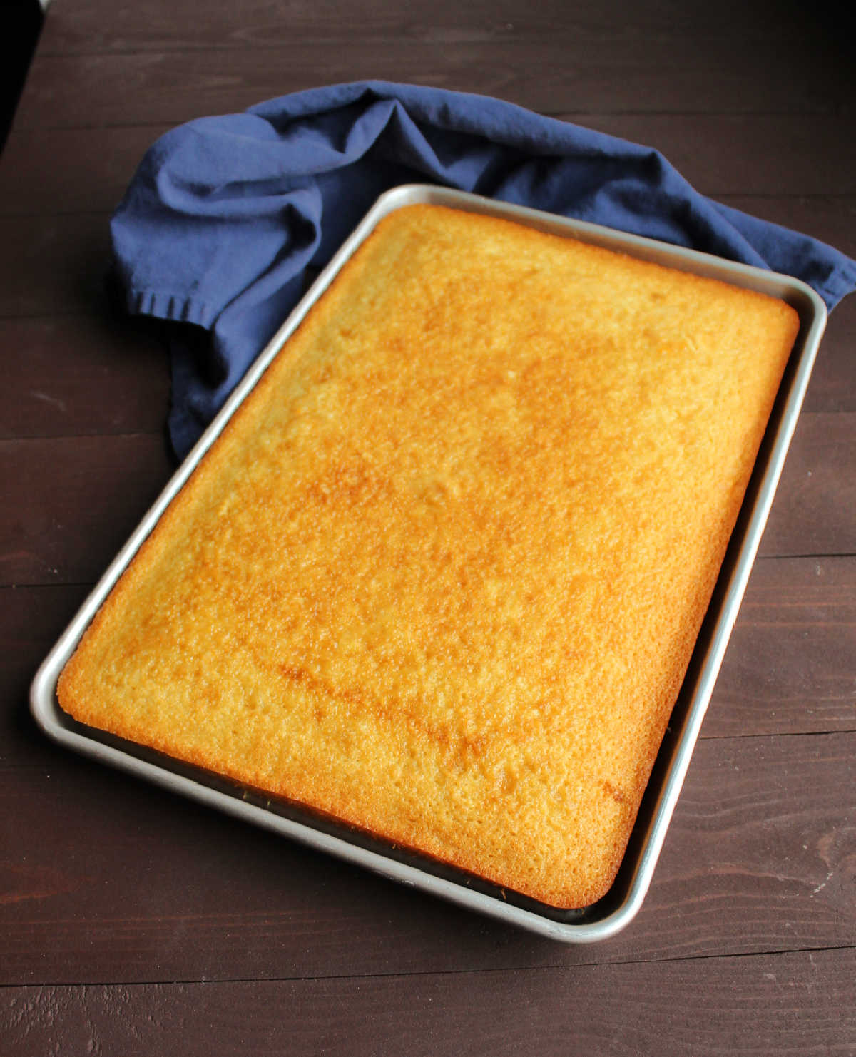 sheet pan filled with golden vanilla cake ready to be frosted.