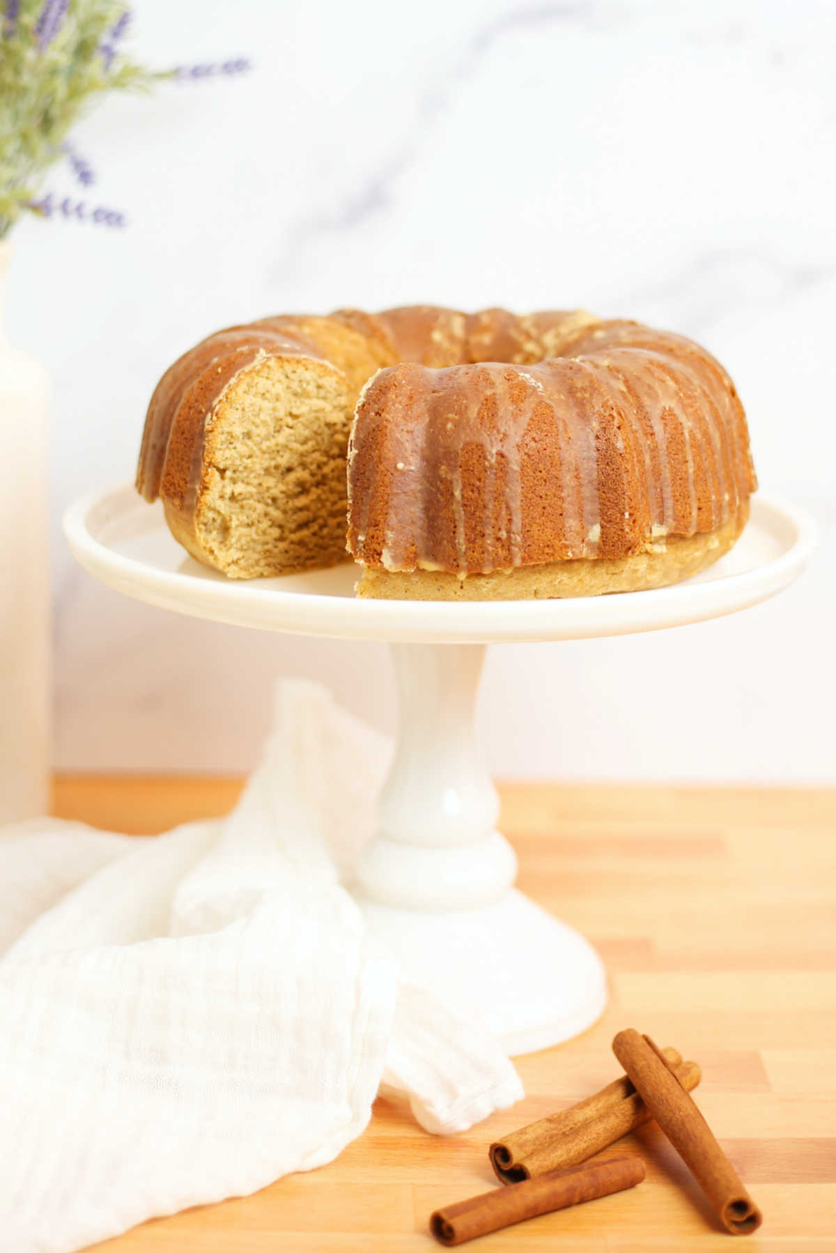 Chai bundt cake with espresso glaze on white cake stand.