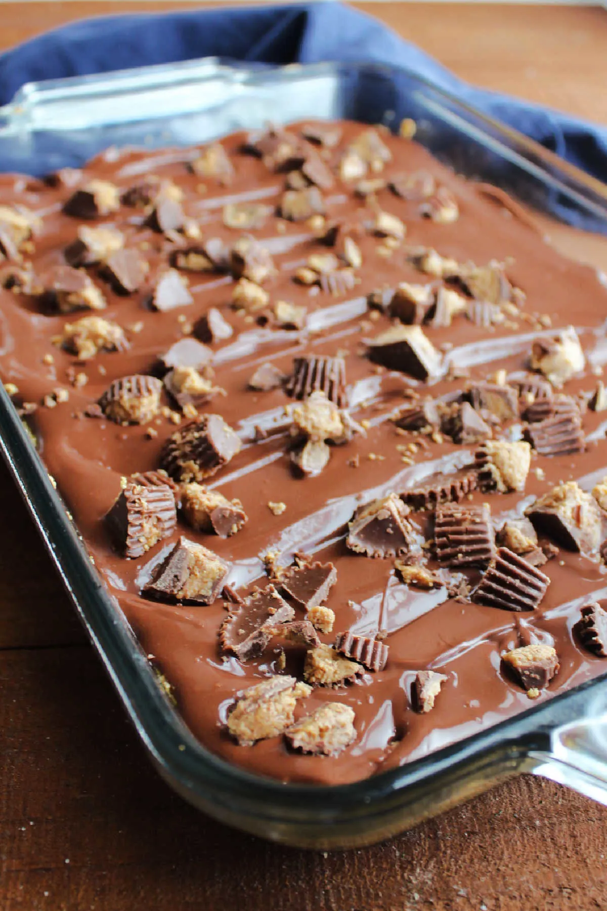 Finished pan of peanut butter bars topped with chocolate and chopped peanut butter cups.