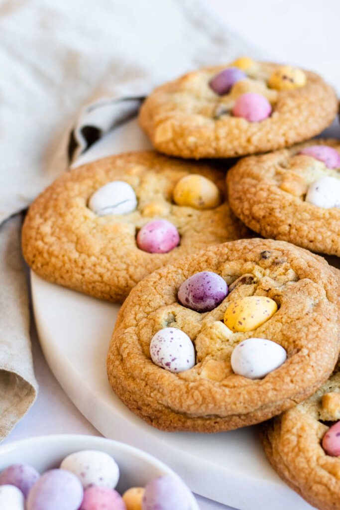 close up of freshly baked cookies with mini chocolate eggs on top.
