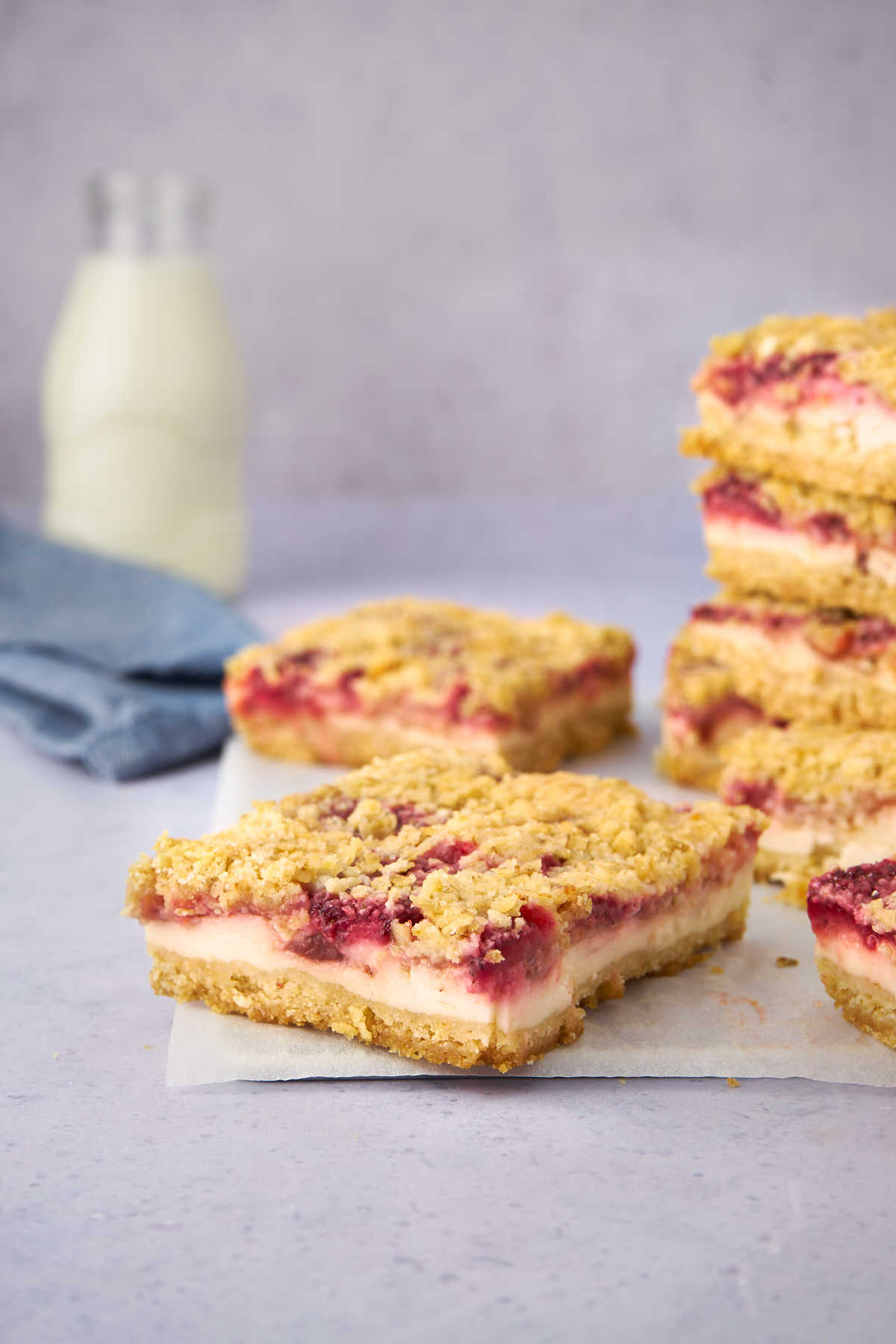 Strawberry yogurt crumble bars with jug of milk in the background.