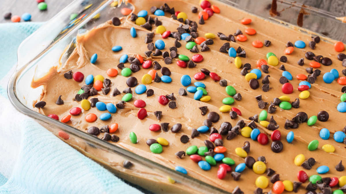 Pan of brownies topped with peanut butter and candies.