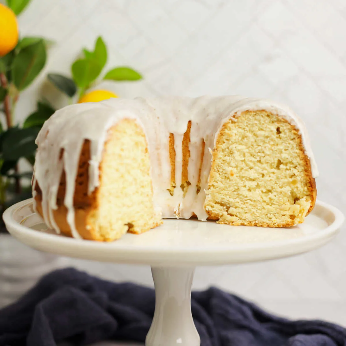 2/3 of lemon bundt cake with white glaze and soft yellow interior showing.