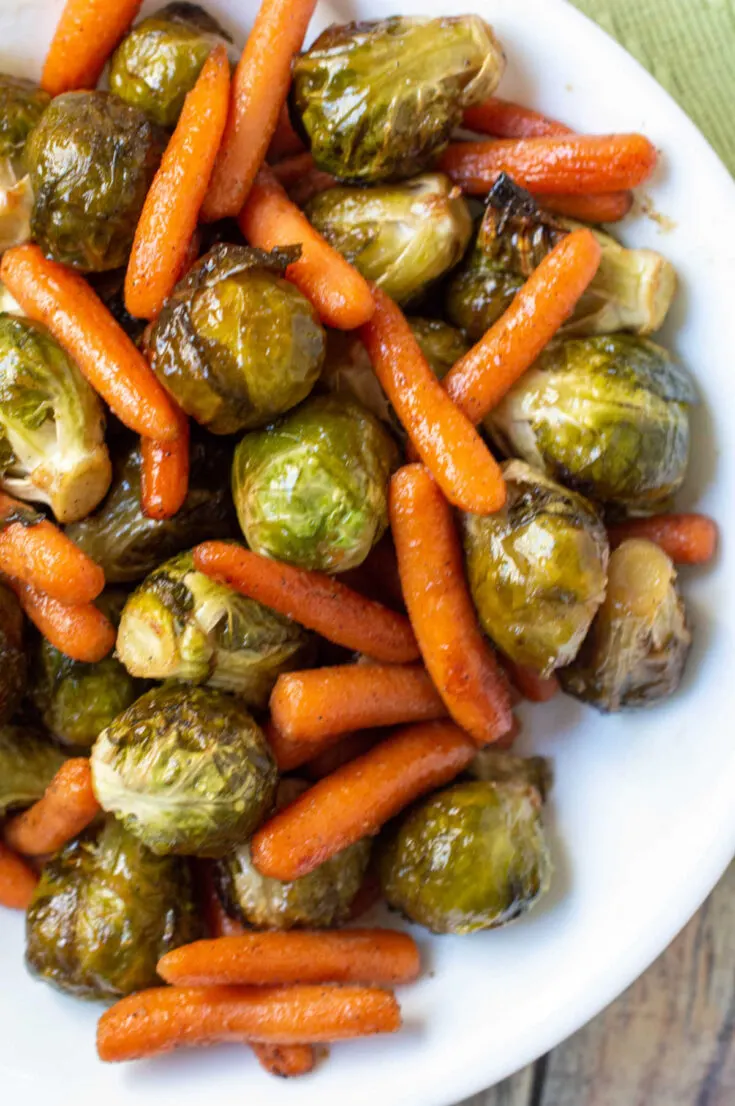 Serving bowl filled with honey roasted carrots and brussels sprouts.