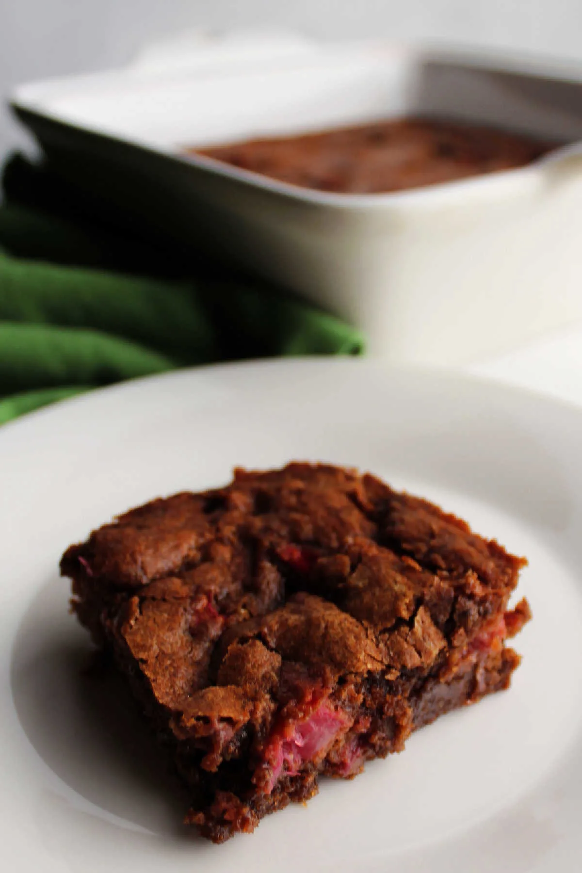 slice of rhubarb brownie in front of pan.
