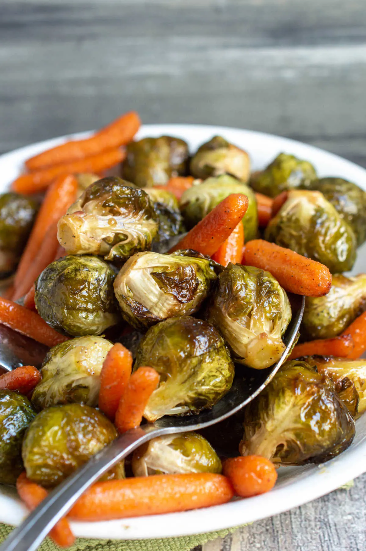 Serving dish filled with roasted brussels sprouts and baby carrots. 
