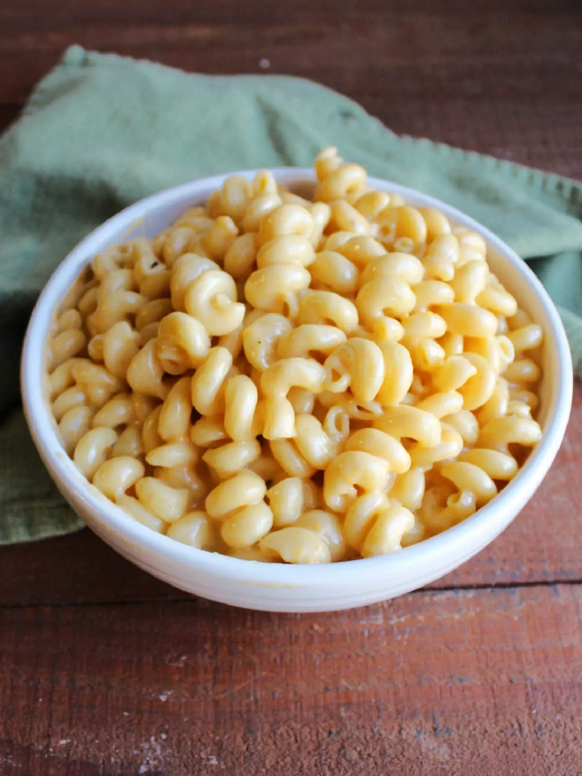 Bowl of curly mac and cheese with rich cheese sauce, ready to eat.