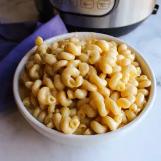 Close bowl of creamy macaroni and cheese with curly noodles.