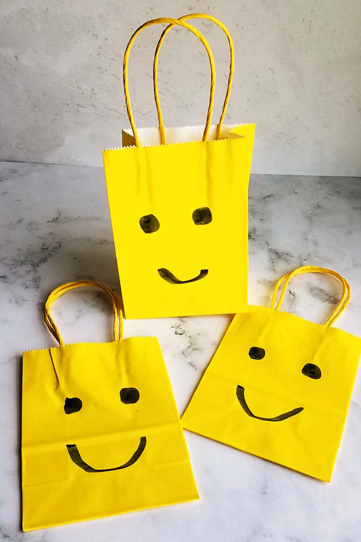yellow treat bags with faces on them to look like lego heads.
