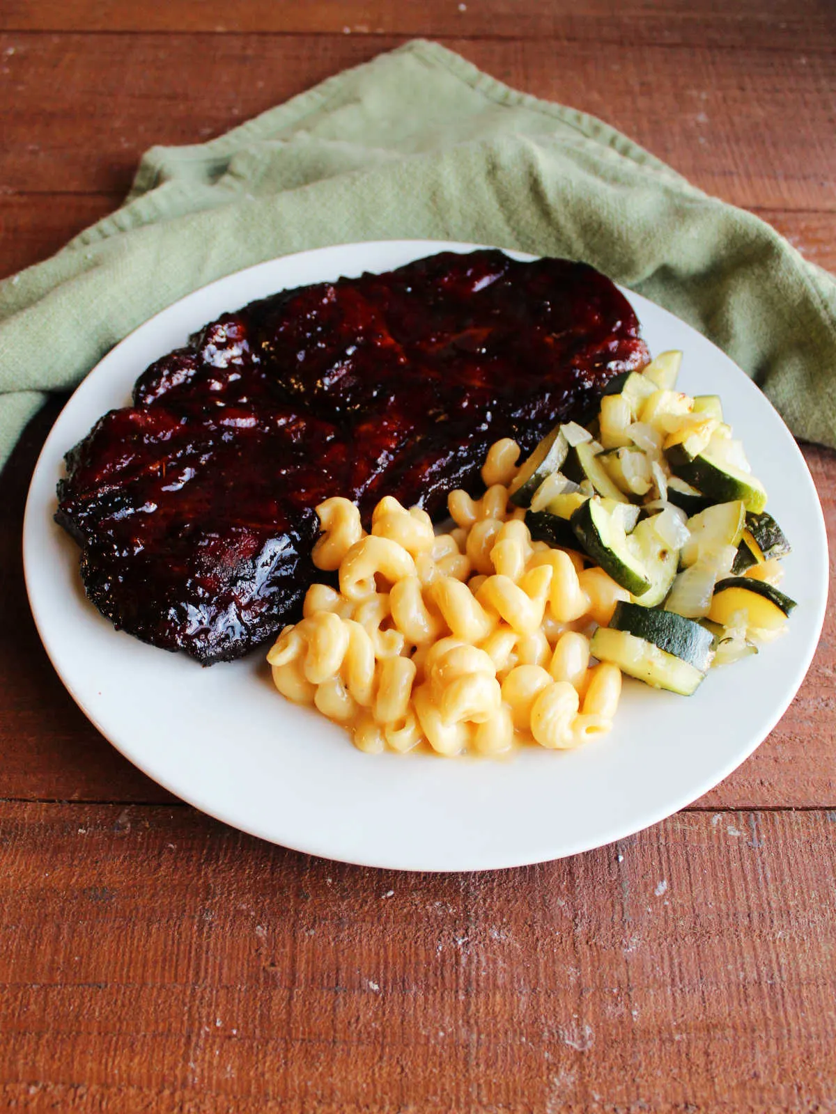 Curly mac and cheese served with BBQ pork steak and zucchini.
