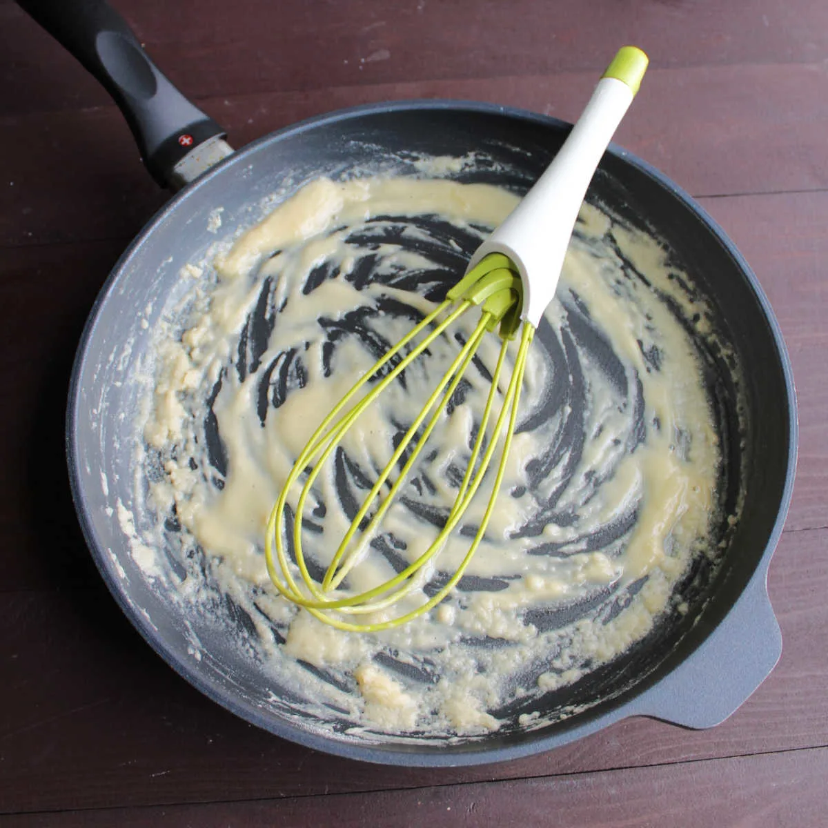making roux with whisk in skillet.