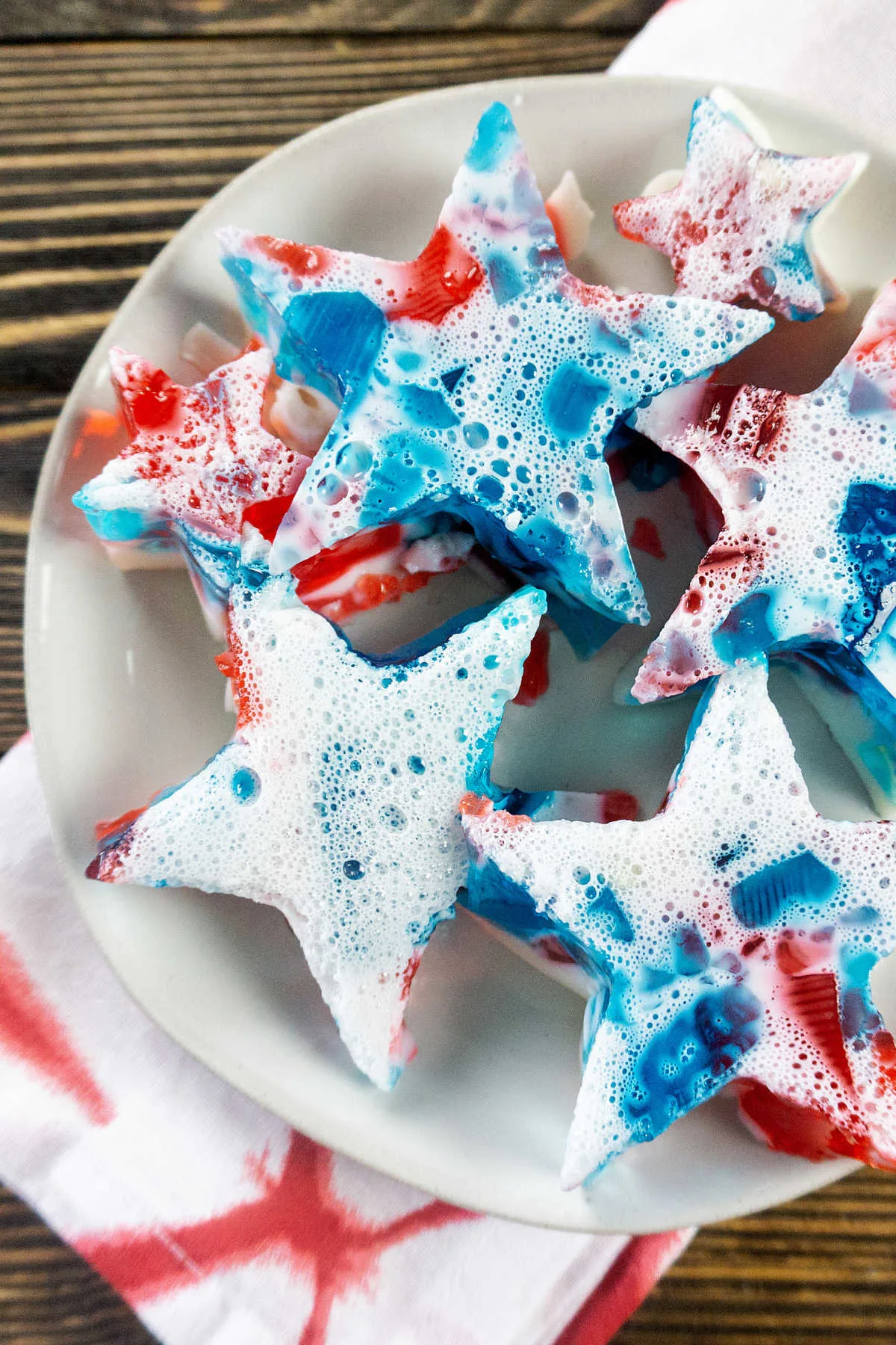 Plate of red white and blue broken glass jello cut into star shapes.