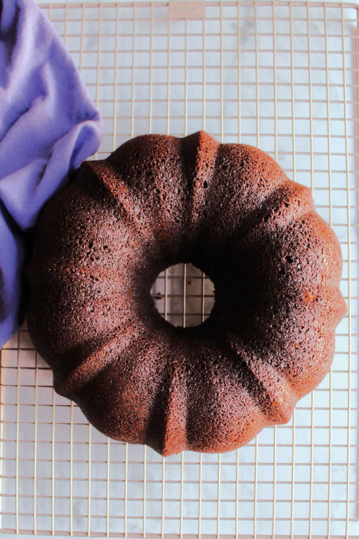 Chocolate bundt cake cooling on wire rack.