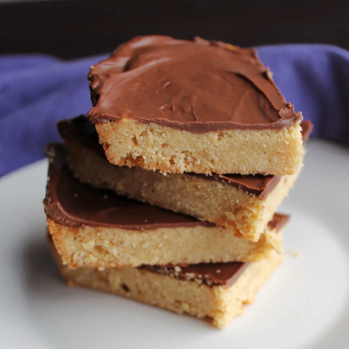 Stack of cookie bars with golden toffee base and chocolate spread over the top.