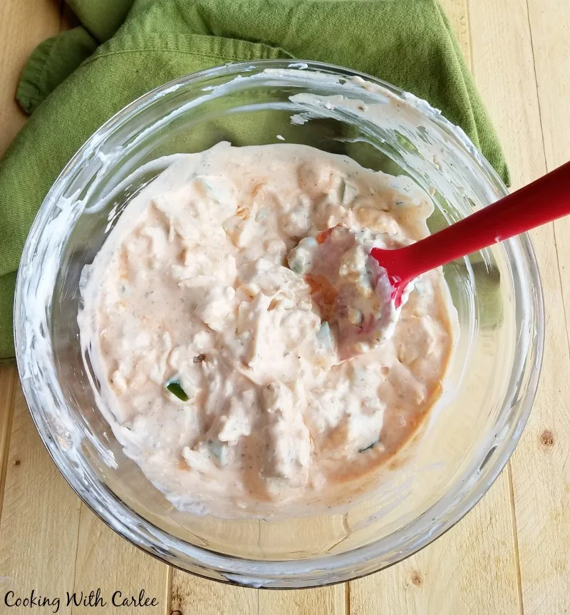 Mixing bowl of cream cheese and buffalo chicken mixture.