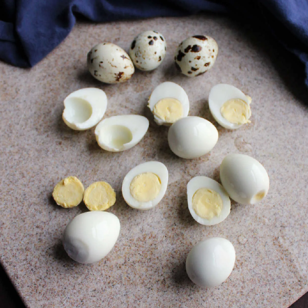 Small boiled quail eggs cut in half with some yolks removed.