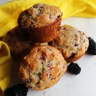 Close stack of golden blackberry muffins ready to eat.