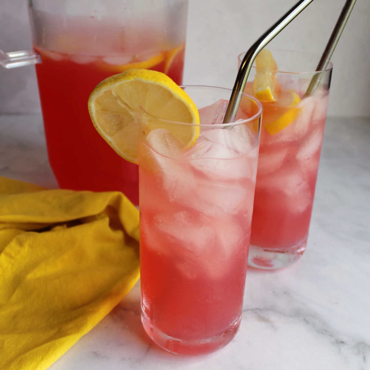 Glasses of homemade pink lemonade on ice.