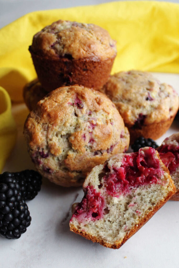 Inside of a blackberry sour cream muffin with big purple berry splotches.
