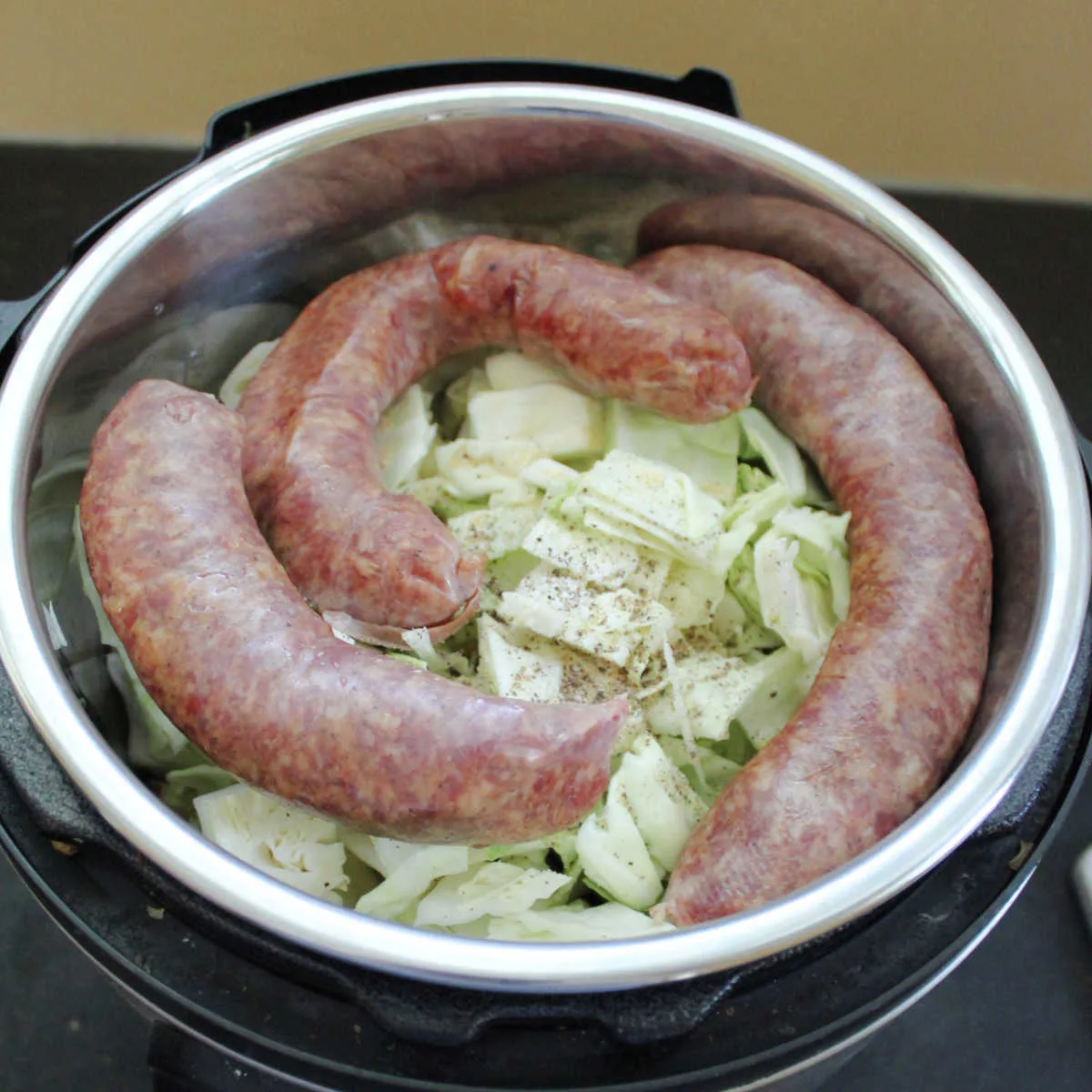 cabbage, potatoes and sausage in instant pot ready to cook.