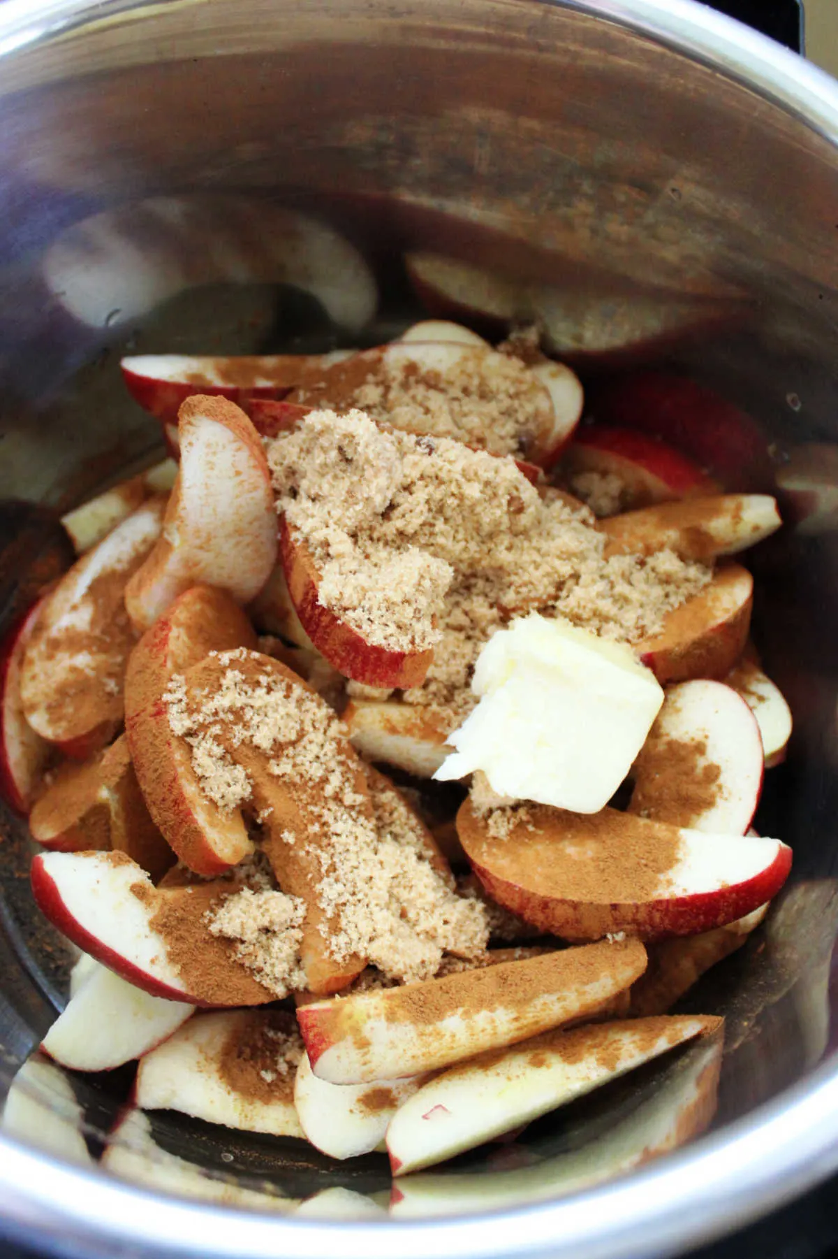 Slices of apples with brown sugar, cinnamon and butter in instant pot.