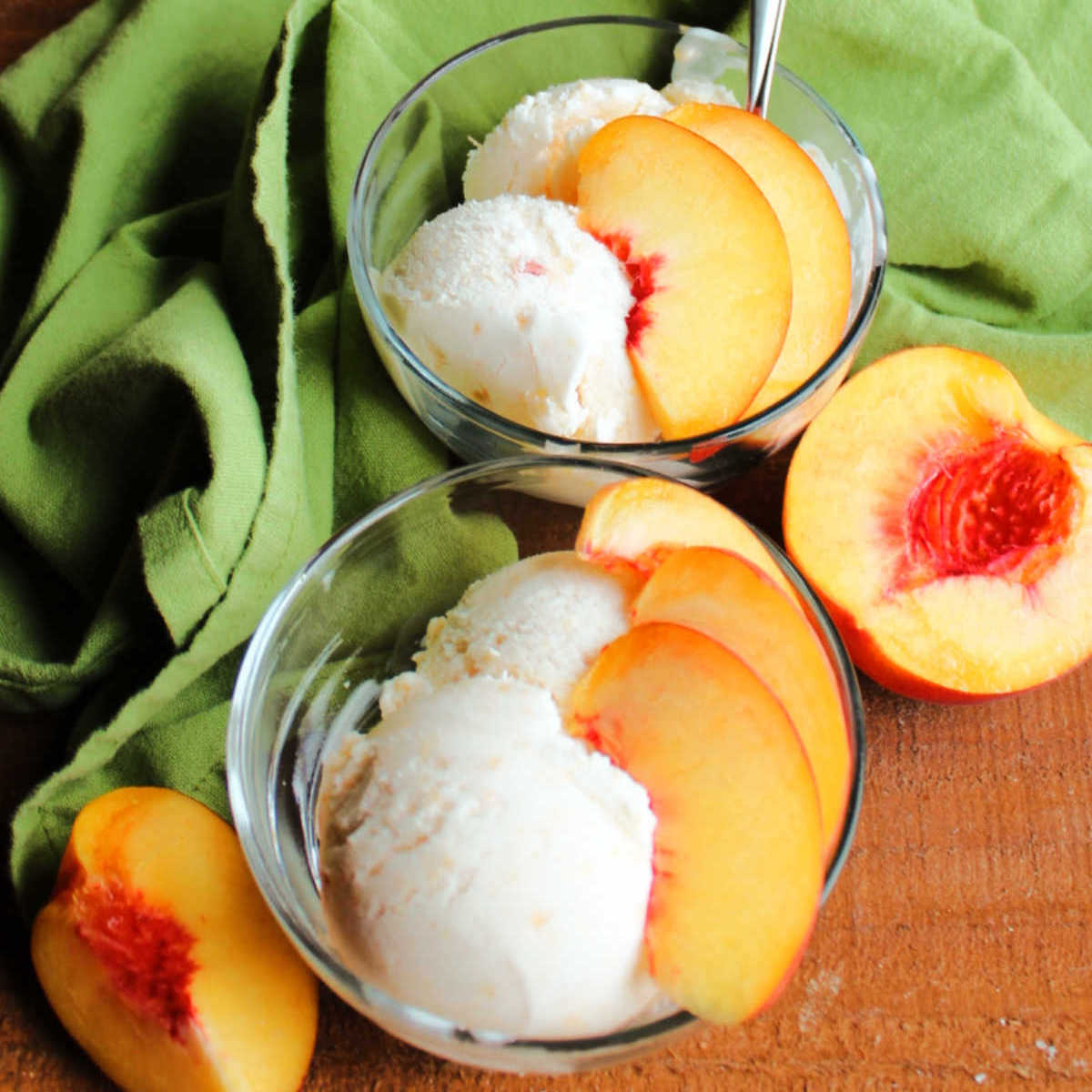 Dishes of homemade peach ice cream with slices of fresh peach on top.