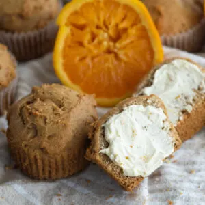 Orange spice muffin cut in half with honey butter spread over it.