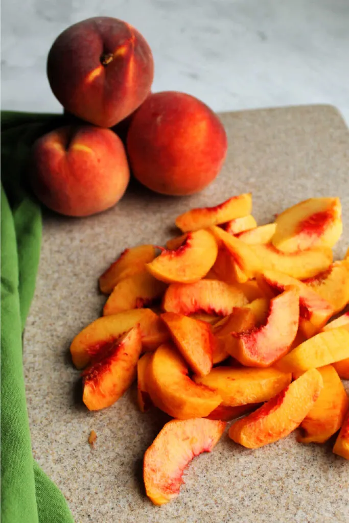 fresh peach slices on cutting board.