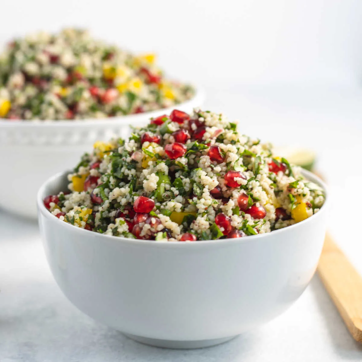Pomegranate Couscous Salad in a white bowl 
