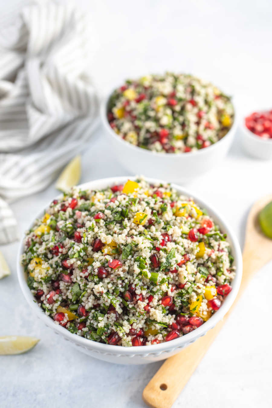 Bowls of brightly color couscous salad with herbs and vinaigrette. 
