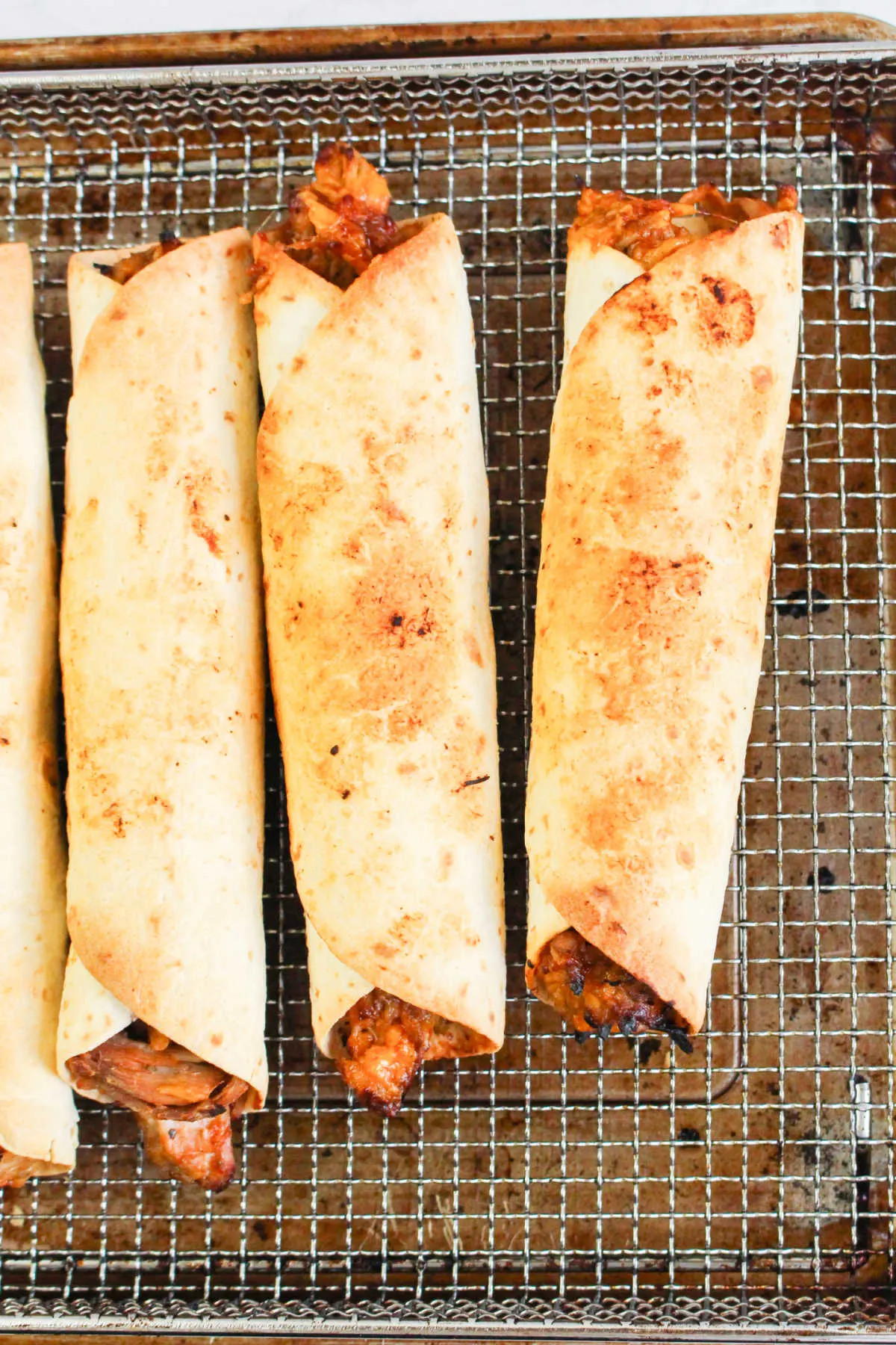 Golden pulled pork taquitos fresh from the air fryer.