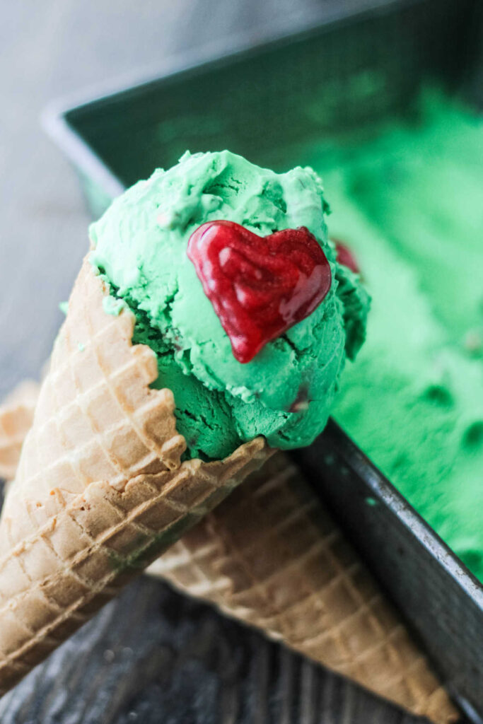 no churn mint ice cream in a cone with red icing heart.