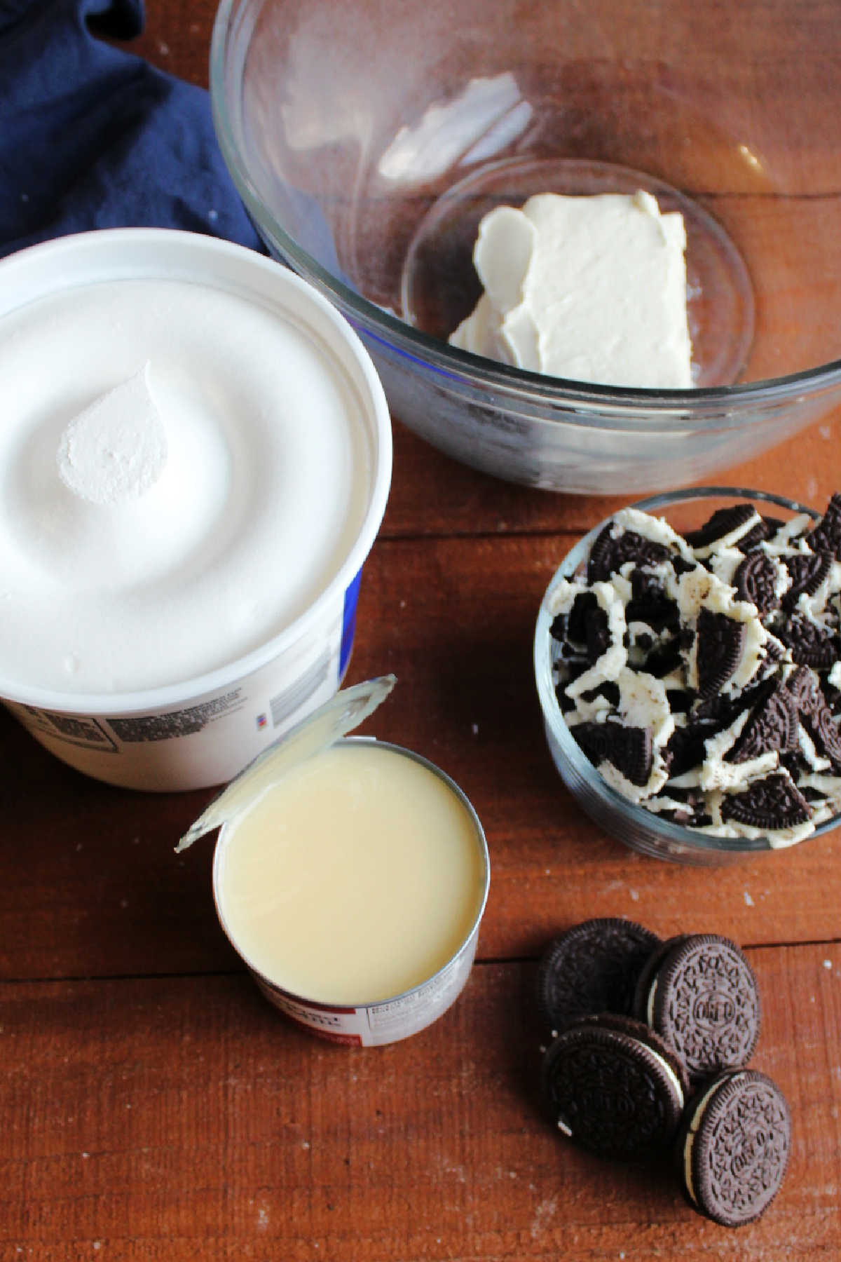 Ingredients for cookie fluff salad with cream cheese, sweetened condensed milk, Oreos and Cool Whip.