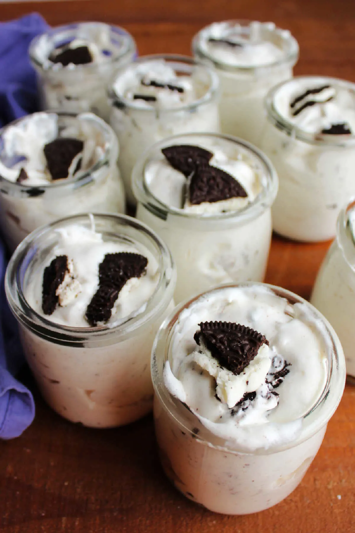 Jars of Oreo fluff salad with bits of cookie on top of each jar.