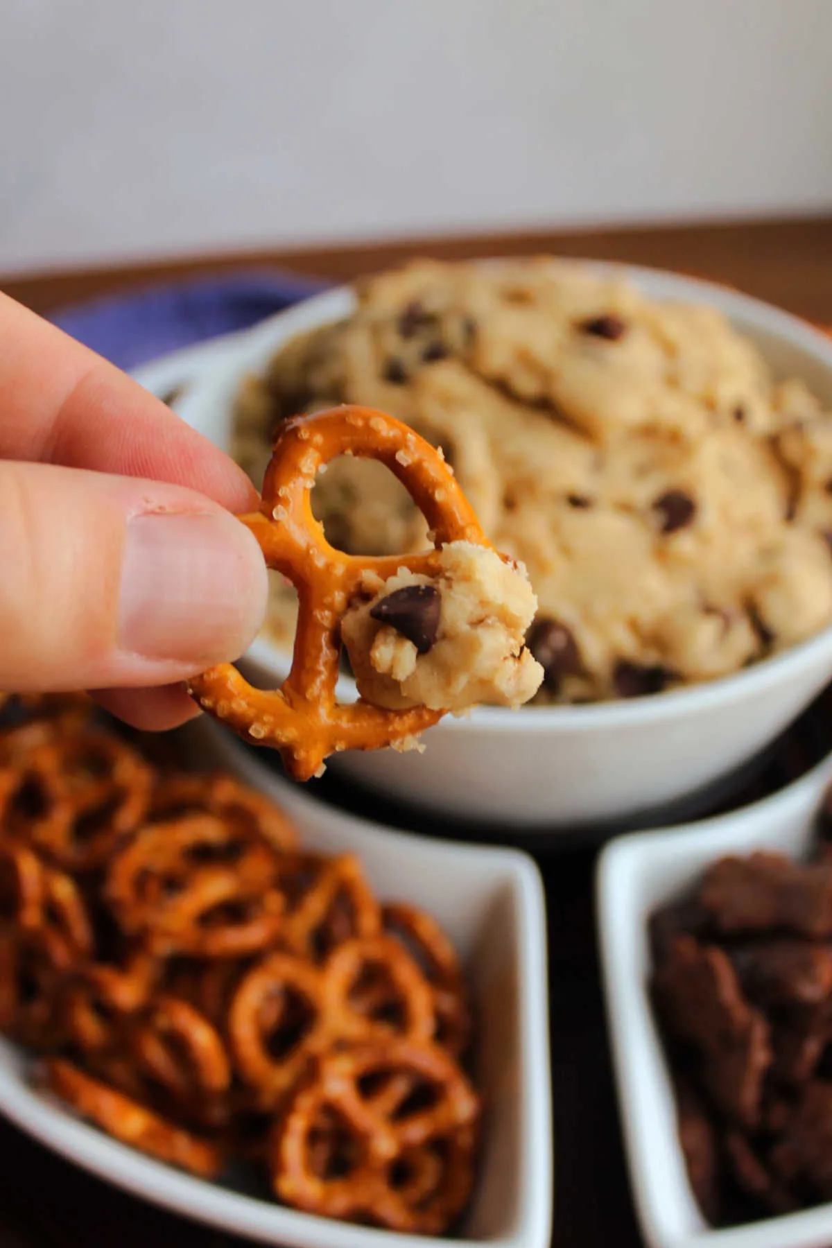 Pretzel dipped into chocolate chip cookie dough ready to eat. 