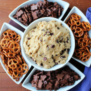 Chip and dip server with chocolate chip cookie dough dip in the center and pretzels and chocolate teddy grahams around the outside.