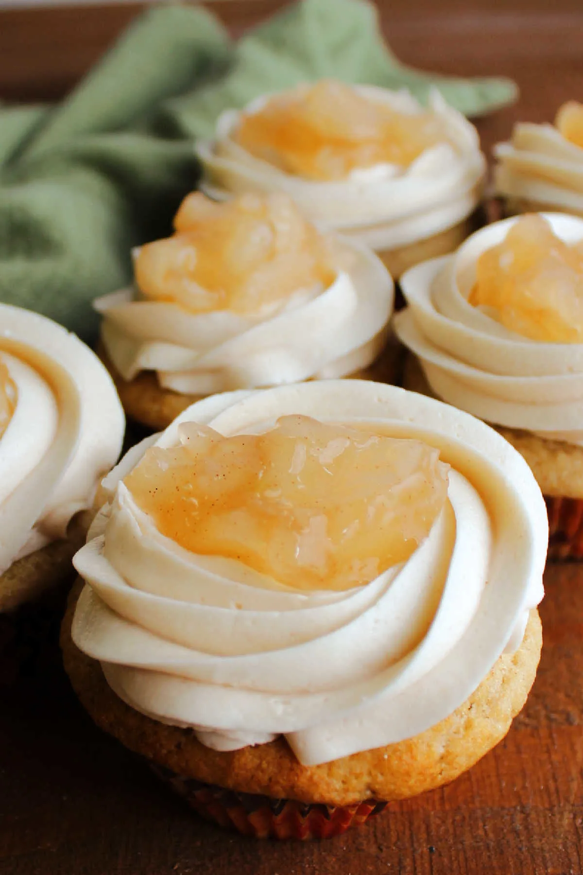 Cinnamon buttercream surrounding apple pie filling on top of cupcake.