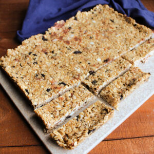 Cutting a sheet of homemade cookies and cream granola into skinny bars that are ready to eat.