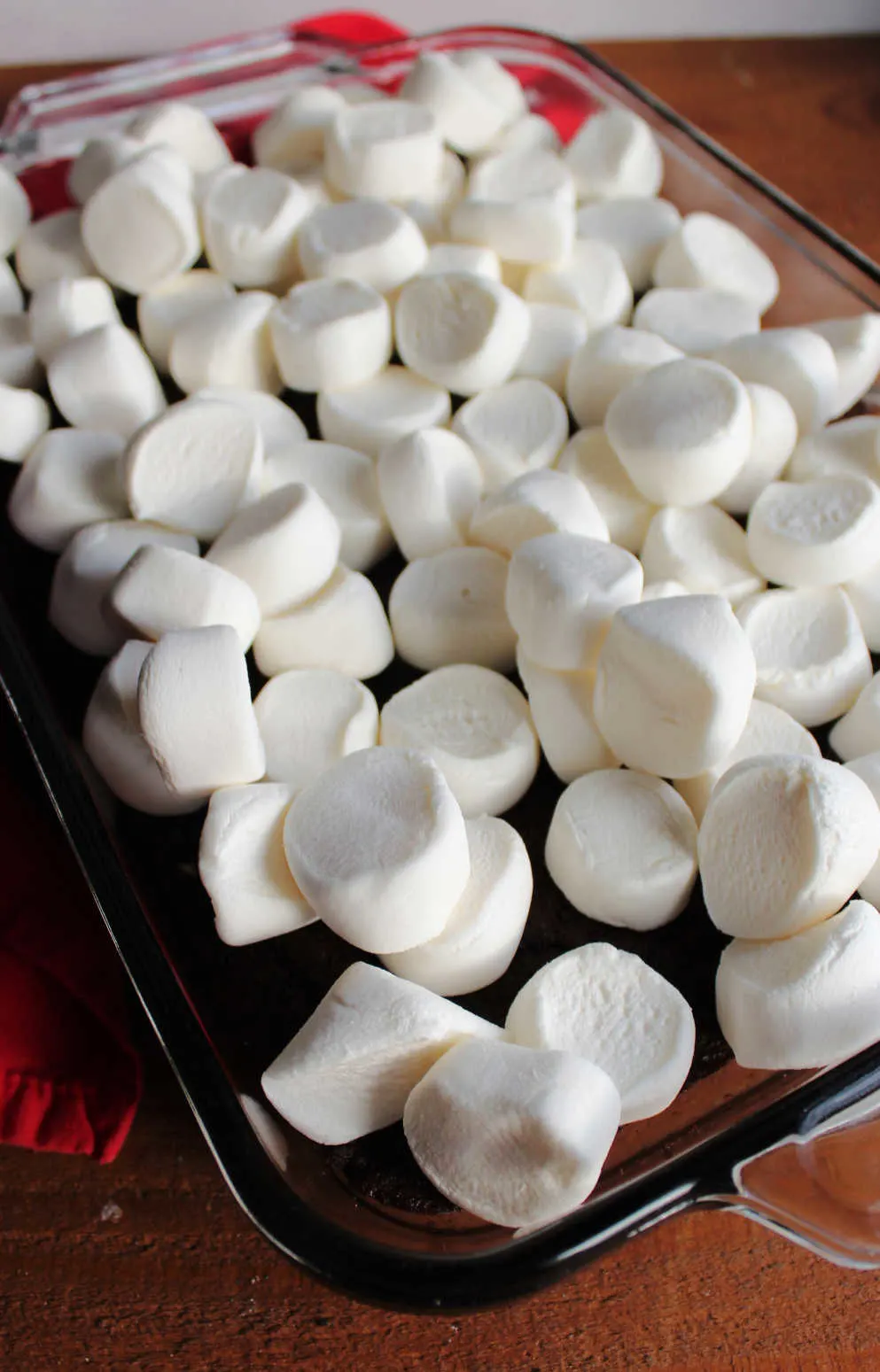 Halved marshmallows on top of brownies, ready to go back in oven.