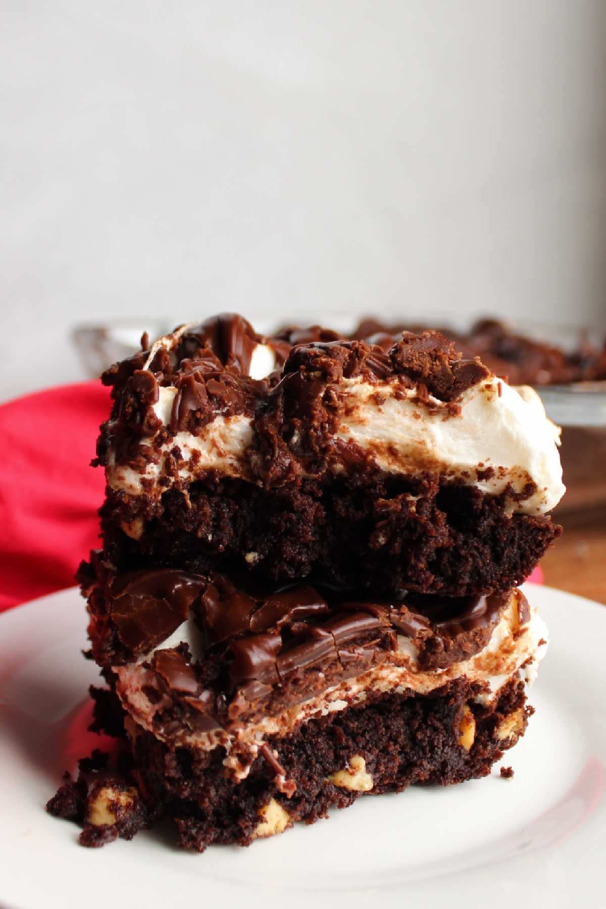 Stack of layered rocky road style brownies on plate. 