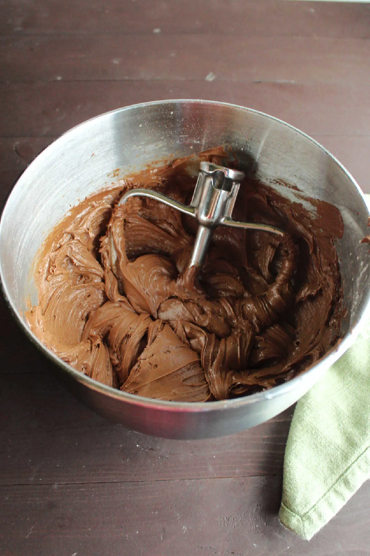Mixer bowl of chocolate frosting ready to go on brownies.